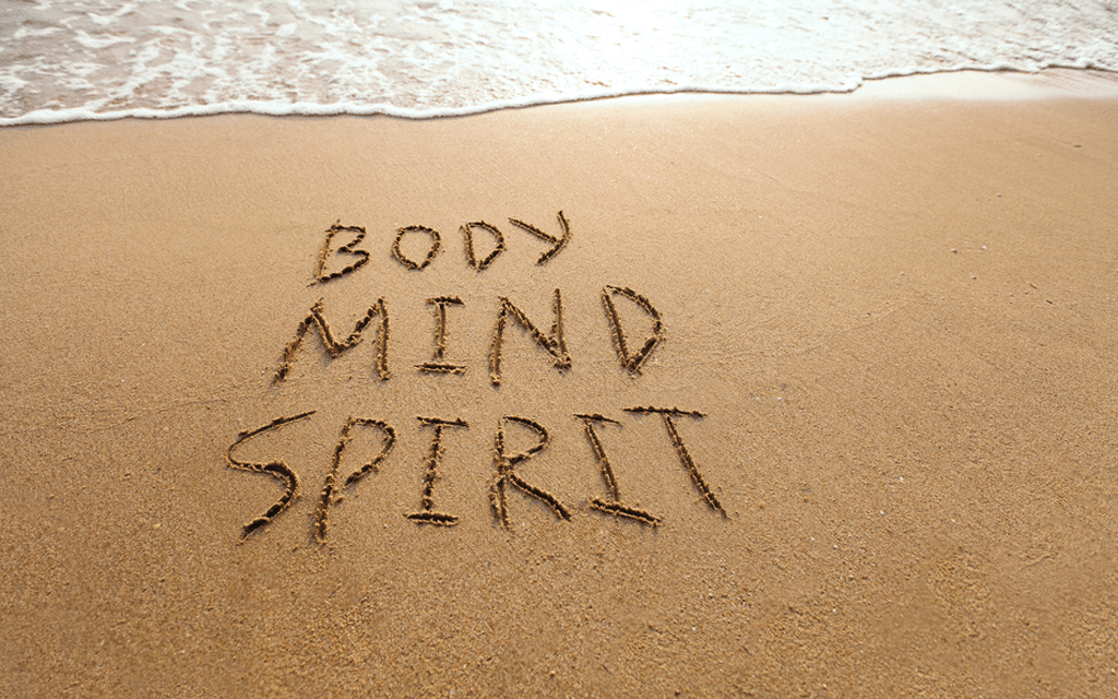 Words body mind and spirit written in beach sand representing prevention strategies drug abuse understanding and treatment resources