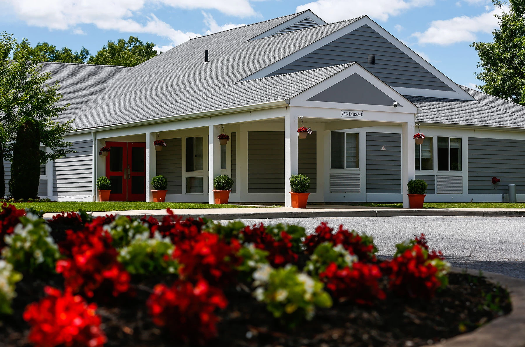 Covered front porch of the Lighthouse treatment facility with landscaped flower beds