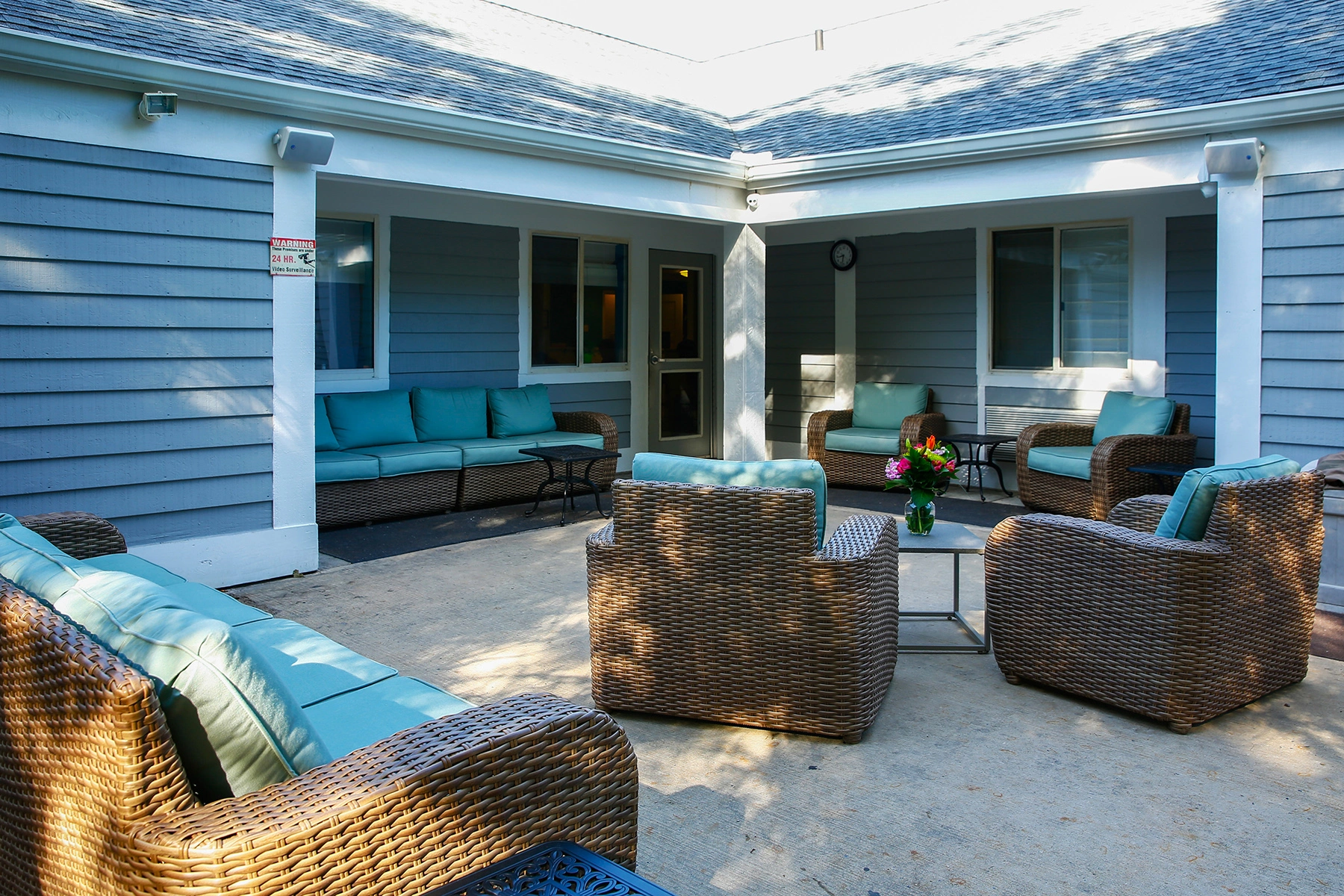 Outdoor patio at Lighthouse with wicker seating and turquoise cushions