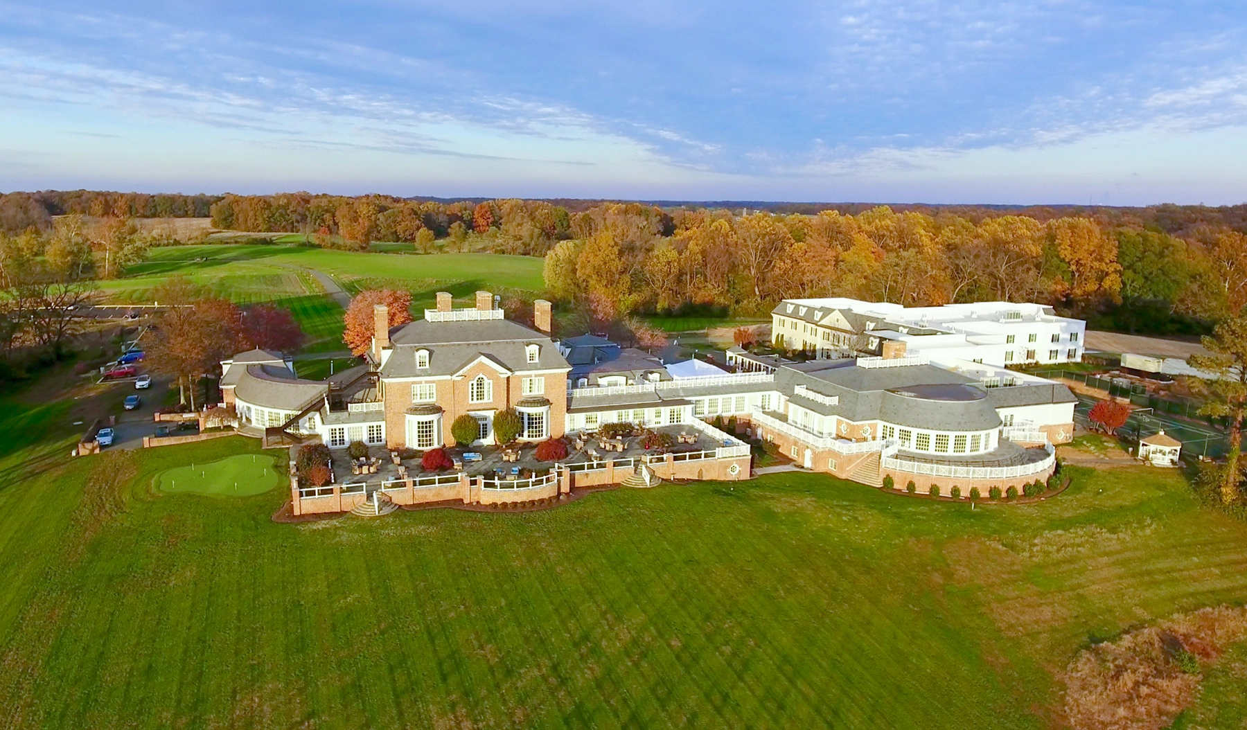 Large estate surrounded by autumn trees